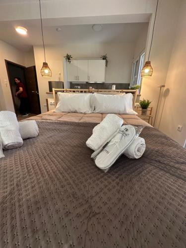 a large bed with two towels and a thermometer on it at Kyma Boutique Suite in Nea Makri