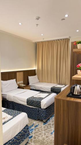 a hotel room with three beds in it at Burj Al Balad Hotel in Mecca