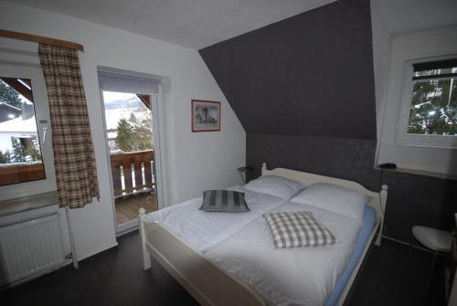 a bedroom with a white bed with two pillows on it at Pension Haus Am Hirschsprung in Willingen