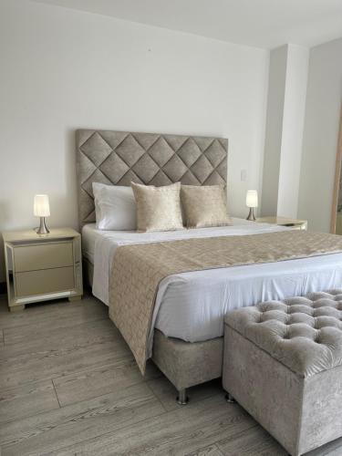 a large bedroom with a large bed and a chair at Torre Ginebra luxury laureles in Medellín