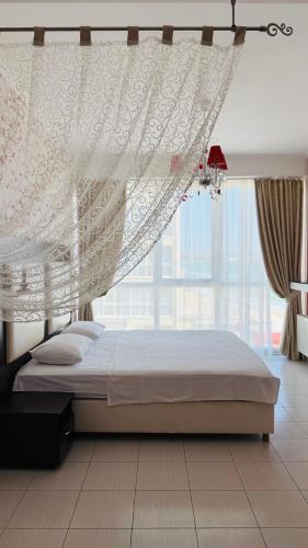 a bedroom with a canopy bed with a large window at Отель у моря Chester in Odesa