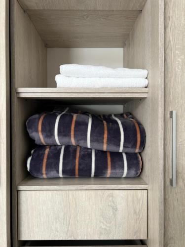 two towels and towels are stacked in a closet at Torre Ginebra luxury laureles in Medellín