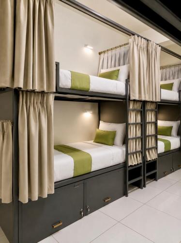 two bunk beds in a room with curtains at VELORA DORMs in Ujjain