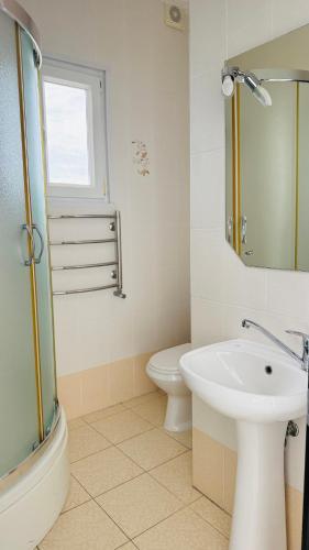 a bathroom with a sink and a toilet at Отель у моря Chester in Odesa