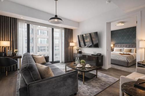 a living room with a couch and a table at The Nobleton Suites - Yorkville in Toronto