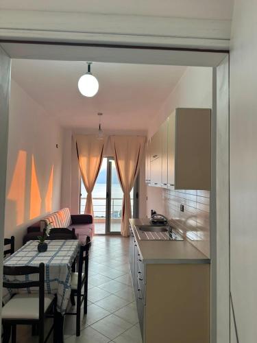 a kitchen and living room with a table and a dining room at Seaview Radhime in Vlorë
