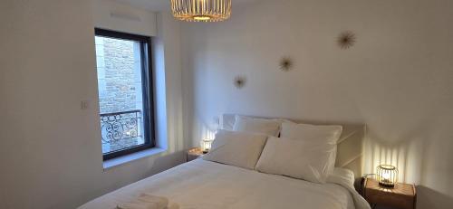 a bedroom with a bed with a window and a chandelier at Klass Loft Kemperle in Quimperlé