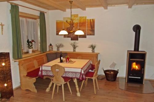 a dining room with a table and a wood stove at "kleines jagdhaus"- Hüttenurlaub in Bayern in Philippsreut