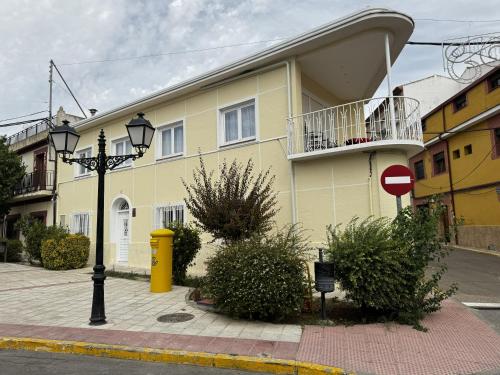 a yellow building with a balcony on a street at La Villa Toledana in Cabañas de la Sagra