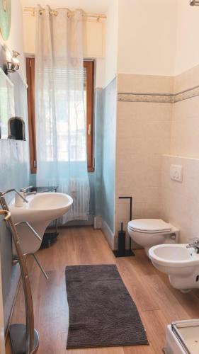 a bathroom with two sinks and a toilet and a window at Como Lake - Balcony, Private Parking, 2 Bathrooms in Cernobbio