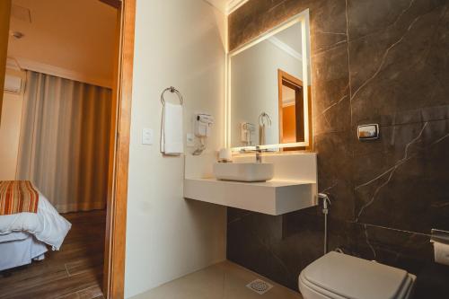 a bathroom with a sink and a toilet at Hotel Alles Blau in Pelotas