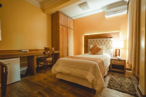 a hotel room with a bed and a desk and a desk at Hotel Alles Blau in Pelotas