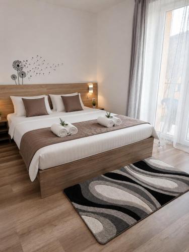 a bedroom with a large bed with two towels at Boróka Panzió in Parád