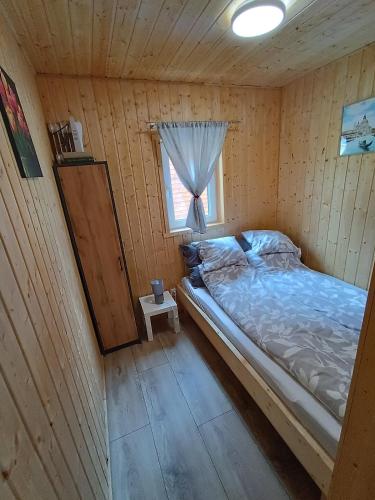 a bedroom with a bed in a wooden cabin at Domki Marianowo in Marianowo