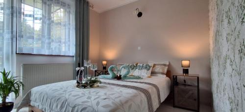 a bedroom with a large bed with white sheets at Willa Jarmar - sala kominkowa z bilardem, wewnętrzny oraz zewnętrzny plac zabaw in Brenna