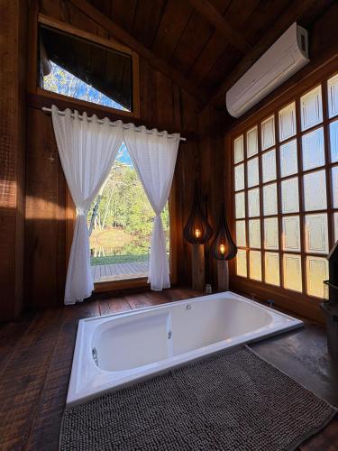 a bath tub in a room with a window at Chalé Do Lago in Garibaldi