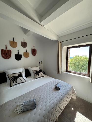a bedroom with a large white bed and a window at Le jardin suspendu in Gordes