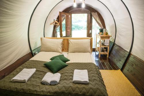 a bed in a dome tent with two pillows at Várlak Glamping in Sub Cetate