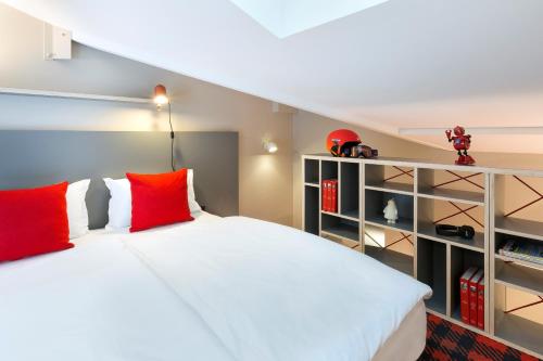 a bedroom with a large white bed with red pillows at RockyPop Chamonix - Les Houches in Les Houches