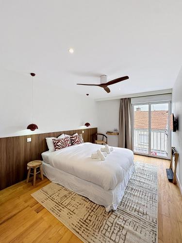 a bedroom with a large white bed and a large window at Maison Plage - boutique hôtel in Saint-Brevin-les-Pins