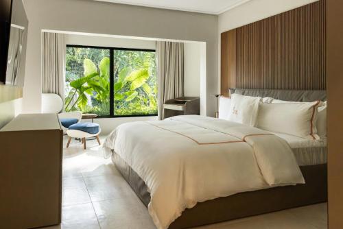 a bedroom with a bed and a chair and a window at Blue Monkey Hotel & Beach Club in Saint James