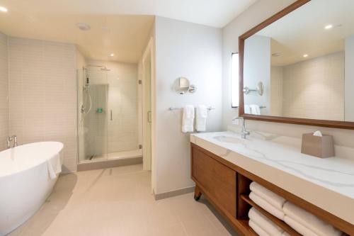 a bathroom with a large mirror and a tub and sink at The Westin Hapuna Beach Resort in Hapuna Beach
