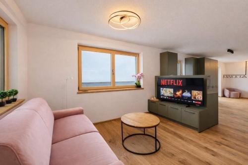 a living room with a couch and a tv at SKYLINE Chalet - Two-Level Penthouse with Private Whirlpool in Mühlen