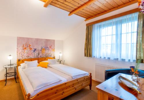 a bedroom with a large bed and a window at Haus Elisabeth, Appartements in Krumpendorf am Wörthersee