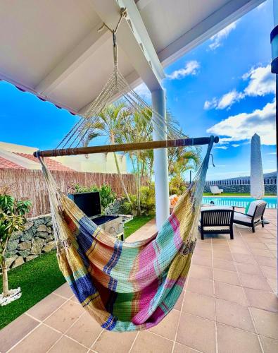 a hammock on a patio with a view of the ocean at Villa La Pintora in Playa de Santiago