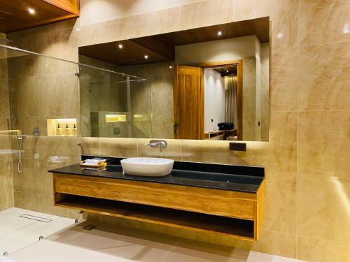 a bathroom with a sink and a mirror at Beach Escape in Arugam Bay