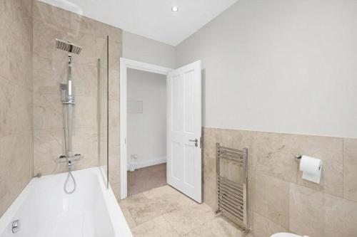 a bathroom with a bath tub and a shower at Flat in Lambeth in London