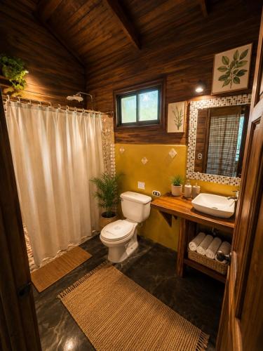 a bathroom with a toilet and a sink and a shower at Anam Apartments in Santa Teresa Beach
