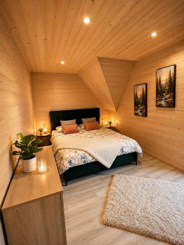 a bedroom with a bed in a wooden room at Villa Alexandra jacuzzi in Kościelisko