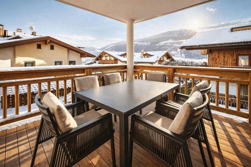 a table and chairs on a balcony with snow at RUHESTUBE - Design Apartment with Balcony in Fügen