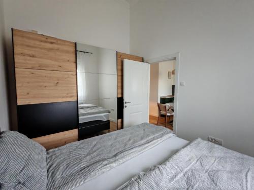 a bedroom with a bed with a large wooden headboard at Apartman Petkov in Palić