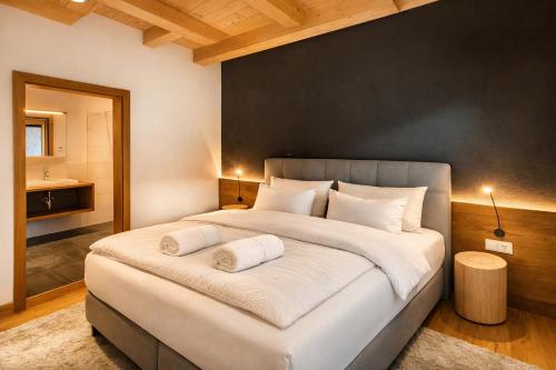 a bedroom with a large bed with two pillows at GLETSCHERBLICKSTUBE - Terrace & Mountain View in Fügen