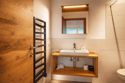 a bathroom with a sink and a mirror at GLETSCHERBLICKSTUBE - Terrace & Mountain View in Fügen