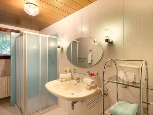 a bathroom with a sink and a shower and a mirror at Haus Elisabeth, Appartements in Krumpendorf am Wörthersee