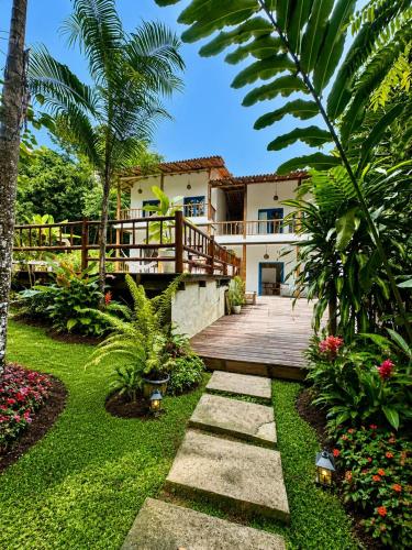 a garden with a wooden walkway in front of a house at Casa Angelina in Trancoso