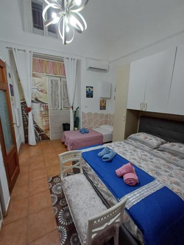 a bedroom with two beds and a chandelier at la casetta di ciacione piazza del plebiscito in Naples