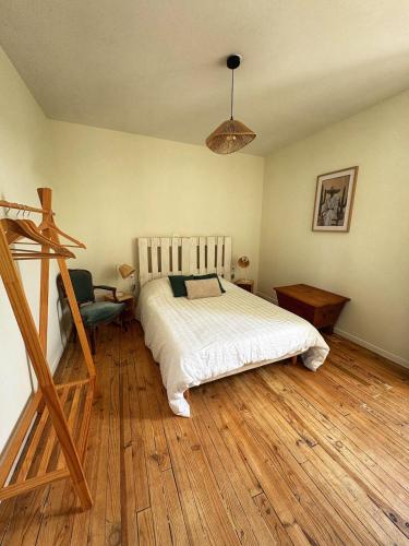 a bedroom with a bed and a chair in it at Escapade Lotoise in Cahors