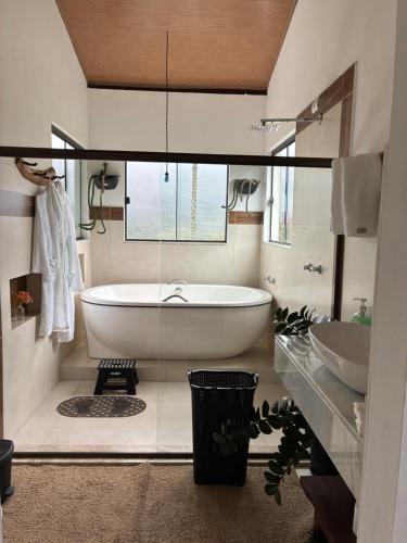 a bathroom with a large tub and two sinks at Casa Águas Claras in Palmeiras