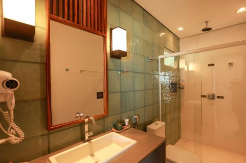 a bathroom with a sink and a shower with a mirror at Hotel Manati in Barra Grande