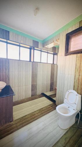 a bathroom with a toilet and a sink at Rooftopwaves penthouse in Daman