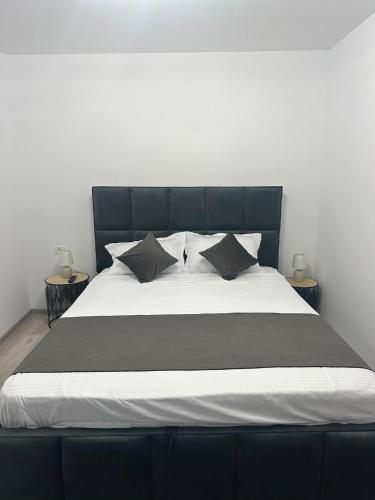 a black and white bed with pillows on it at Nova Residence Craiova in Craiova