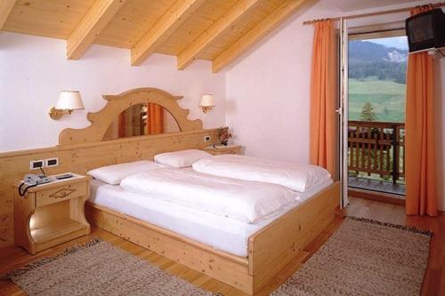 a bedroom with a large bed and a window at Hotel San Leonardo in Badia