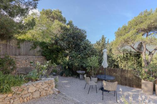 a patio with a table and chairs and an umbrella at Studio lumineux avec jardin privé et parking in La Turbie