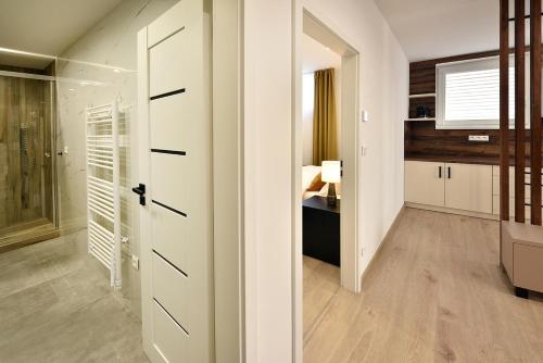 a room with a hallway with a door and a bedroom at Apartmány Virbo in Vrbov