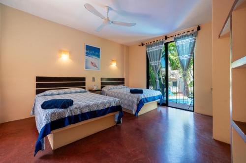 a bedroom with two beds and a ceiling fan at Hotel Rivera Del Mar in Puerto Escondido