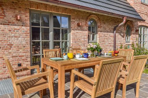a wooden table and chairs on a patio at Die Perle von Wenningstedt in Braderup